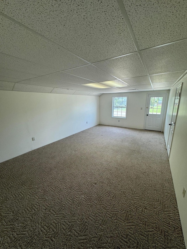 carpeted spare room featuring a drop ceiling