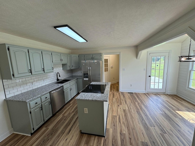 kitchen featuring sink, tasteful backsplash, a textured ceiling, dark hardwood / wood-style flooring, and stainless steel appliances