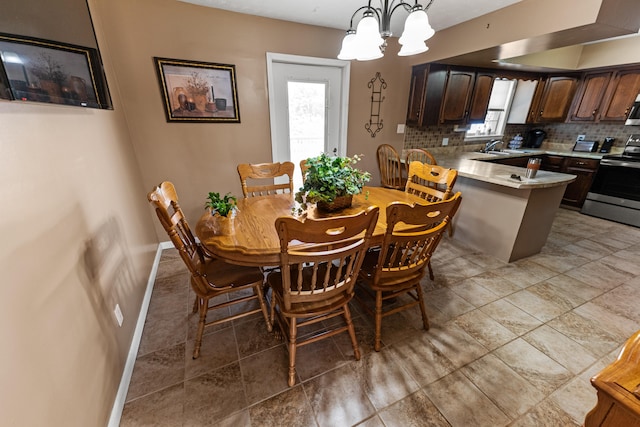 dining area with a chandelier, sink, and light tile patterned floors