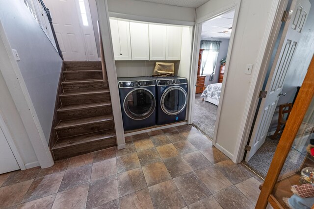 washroom featuring cabinets, washer and clothes dryer, and dark tile patterned flooring