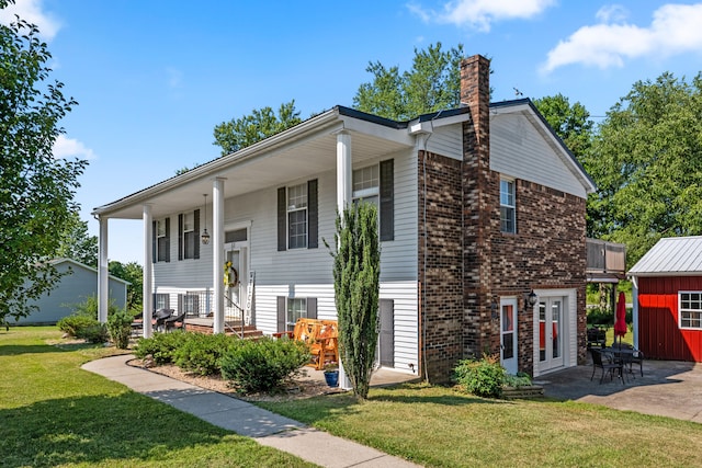 bi-level home with a patio area, a front yard, and a storage shed