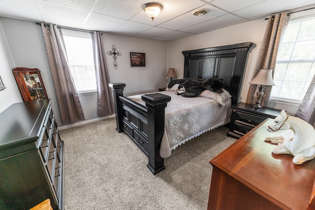 bedroom with light carpet and a drop ceiling