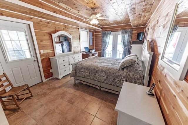 tiled bedroom featuring wooden walls, french doors, wood ceiling, and ceiling fan