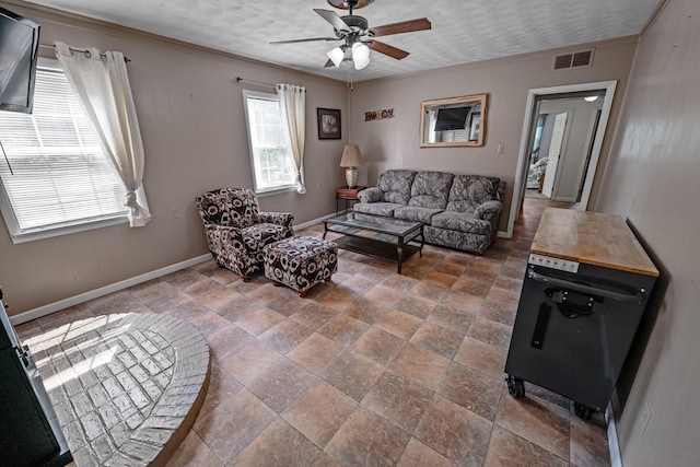 living room featuring crown molding, ceiling fan, and tile patterned floors