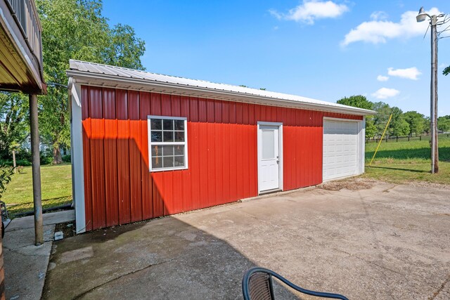 view of outdoor structure with a garage and a lawn