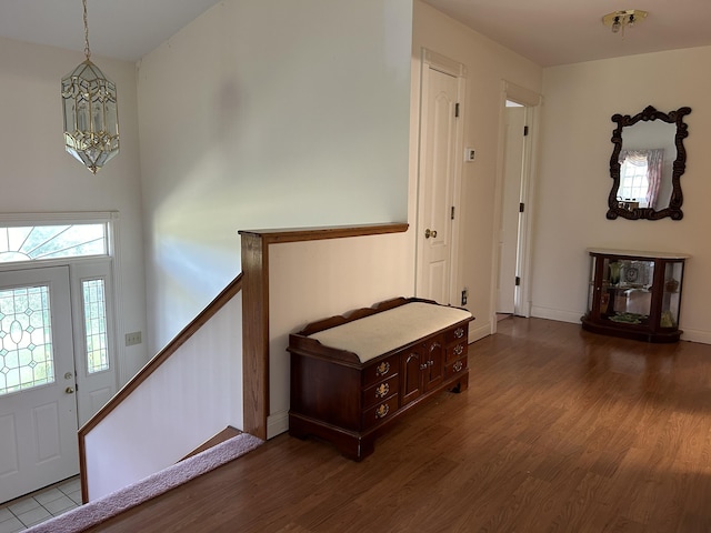 foyer entrance with dark wood-type flooring and an inviting chandelier