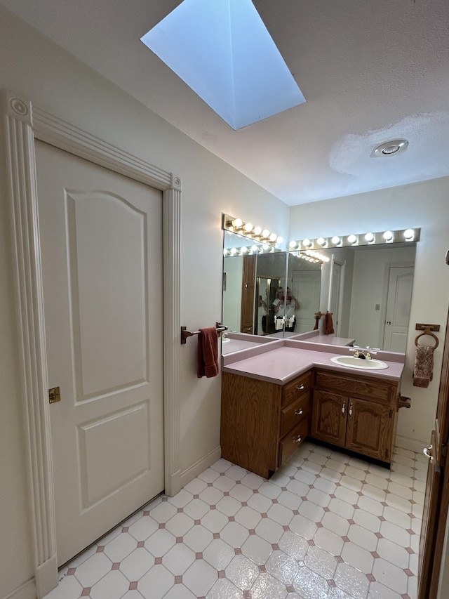 bathroom featuring a skylight and vanity