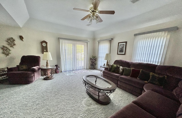 living room featuring ceiling fan, light carpet, and a tray ceiling