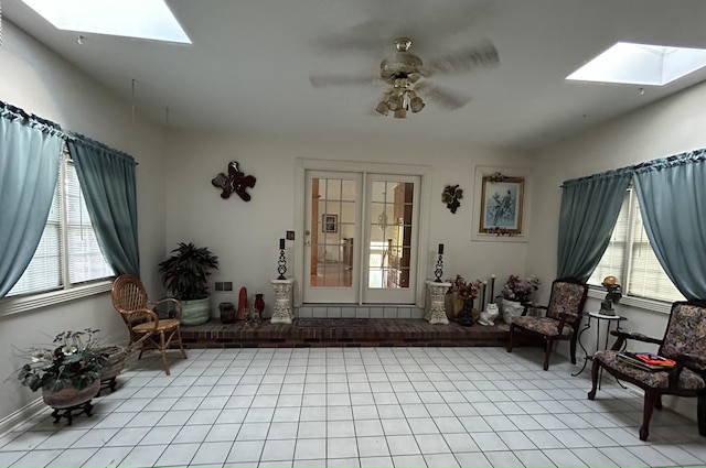 living area with ceiling fan, a skylight, and a wealth of natural light