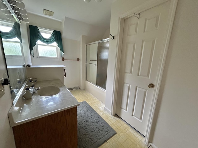 bathroom featuring vanity and enclosed tub / shower combo