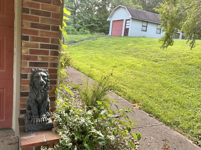 view of yard featuring a garage and an outbuilding