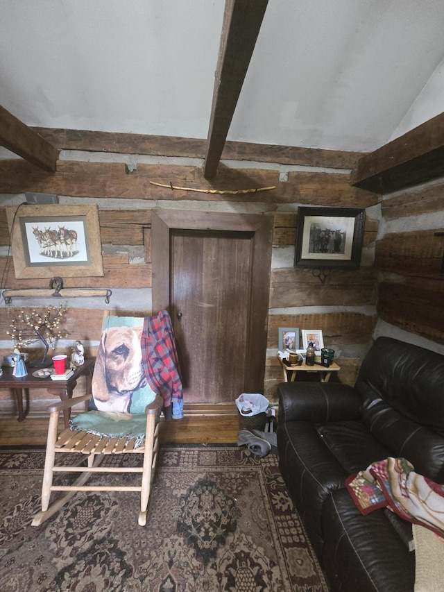 living area with lofted ceiling with beams and wood walls