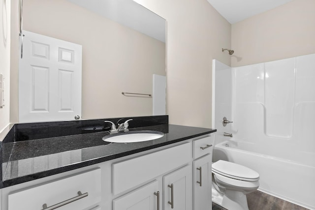 full bathroom featuring toilet, hardwood / wood-style flooring, shower / bathing tub combination, and vanity