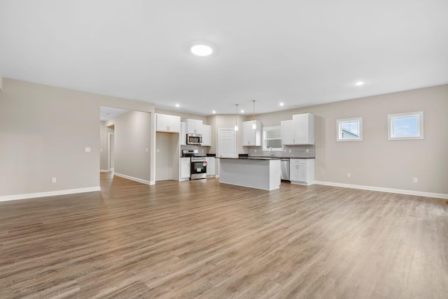 unfurnished living room featuring light hardwood / wood-style flooring and sink