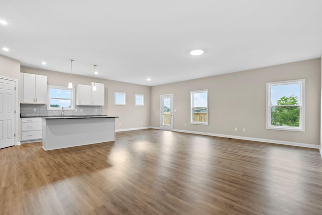 unfurnished living room featuring dark hardwood / wood-style floors and sink