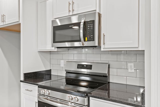 kitchen featuring white cabinets, decorative backsplash, dark stone counters, and appliances with stainless steel finishes