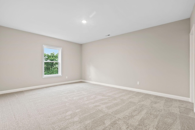 spare room featuring light carpet