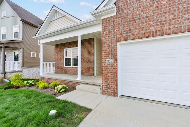 view of exterior entry with a garage and covered porch