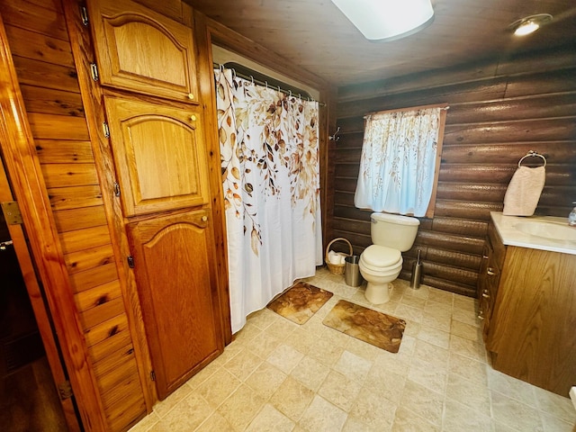 bathroom featuring toilet, log walls, and vanity