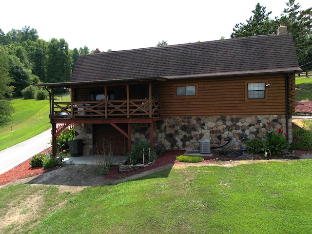 rear view of house with a lawn and central air condition unit