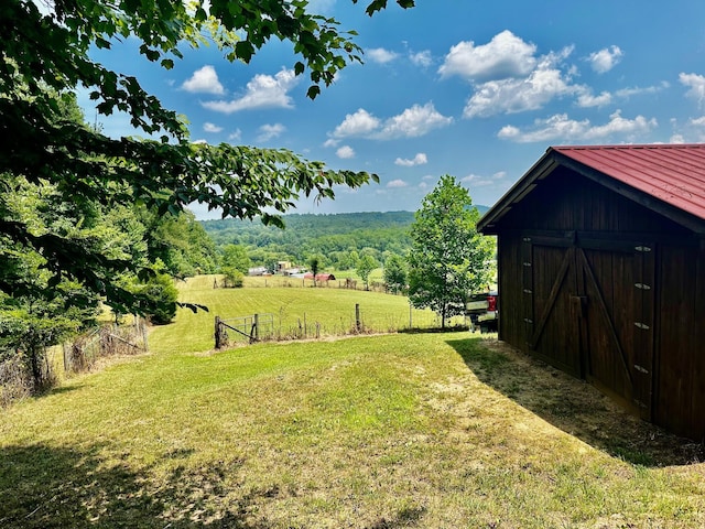 view of yard featuring a rural view and a storage unit