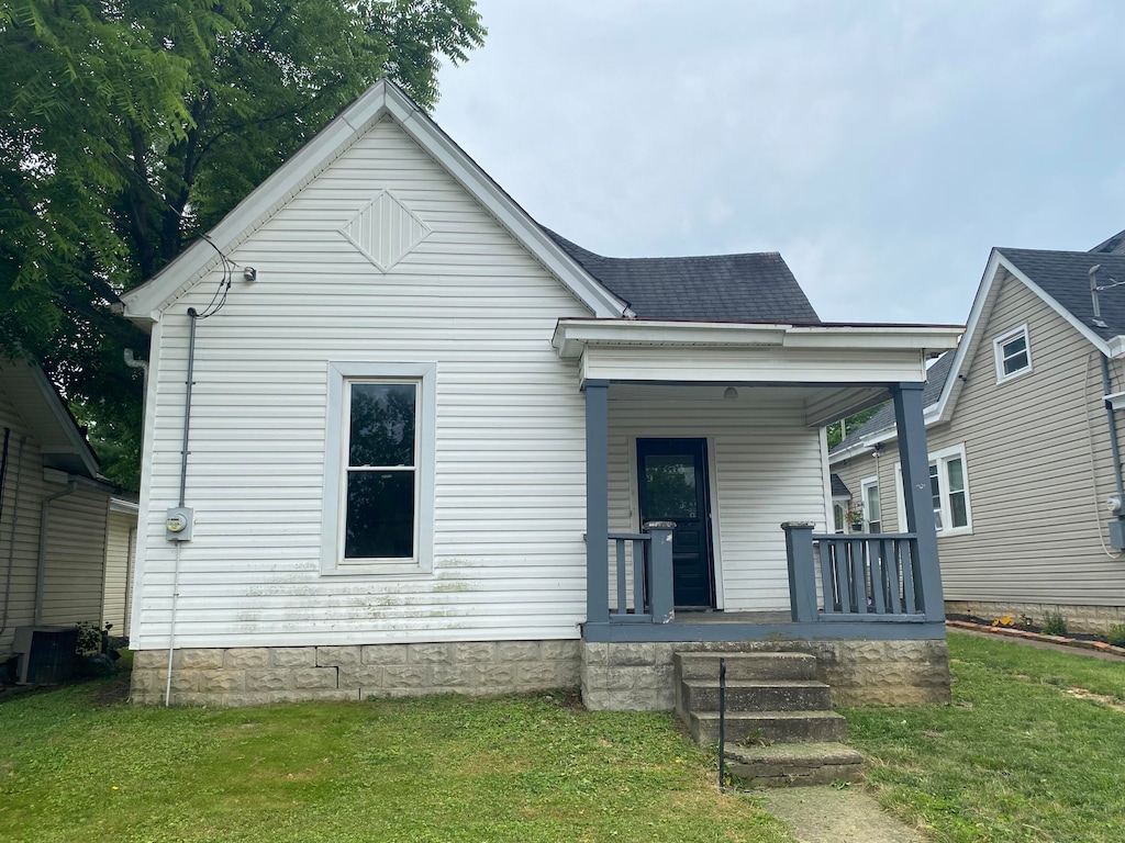 view of front facade featuring central AC, a front lawn, and a porch