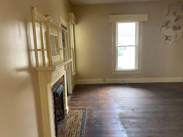 unfurnished living room featuring a fireplace and dark hardwood / wood-style flooring