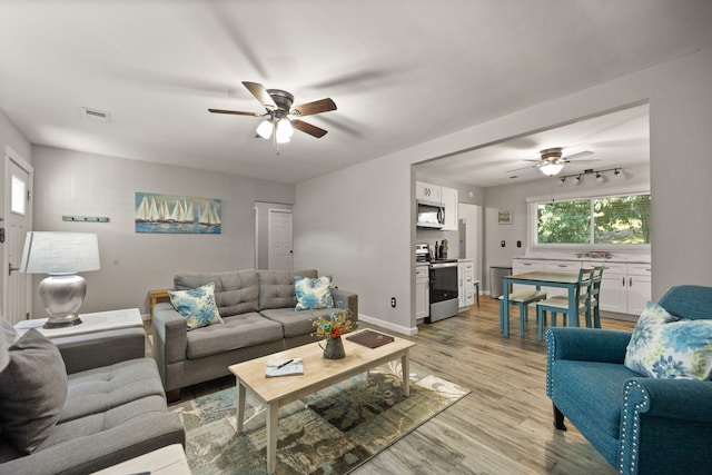 living room featuring ceiling fan and light hardwood / wood-style flooring