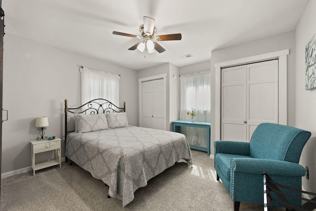 bedroom featuring ceiling fan, carpet floors, and two closets