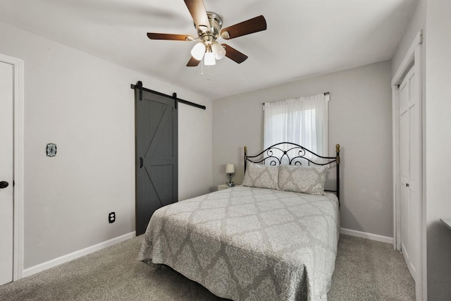 carpeted bedroom featuring ceiling fan, a barn door, and a closet