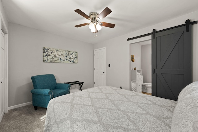 carpeted bedroom featuring ensuite bathroom, a barn door, and ceiling fan