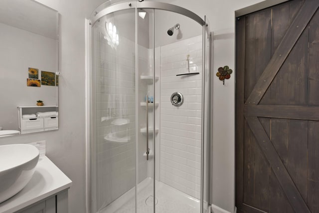 bathroom featuring vanity and a shower with door