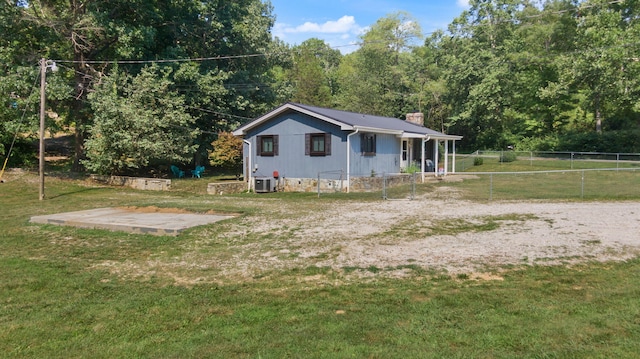 view of side of home with central AC unit and a lawn