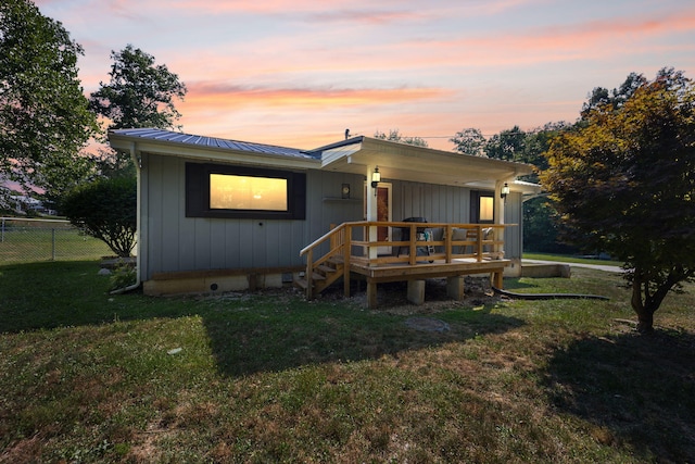 back house at dusk with a lawn