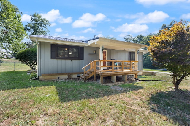 rear view of house featuring a yard and a deck