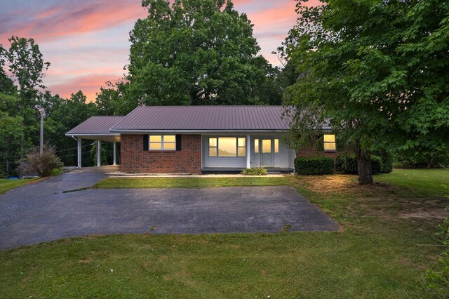 ranch-style house featuring a porch and a yard