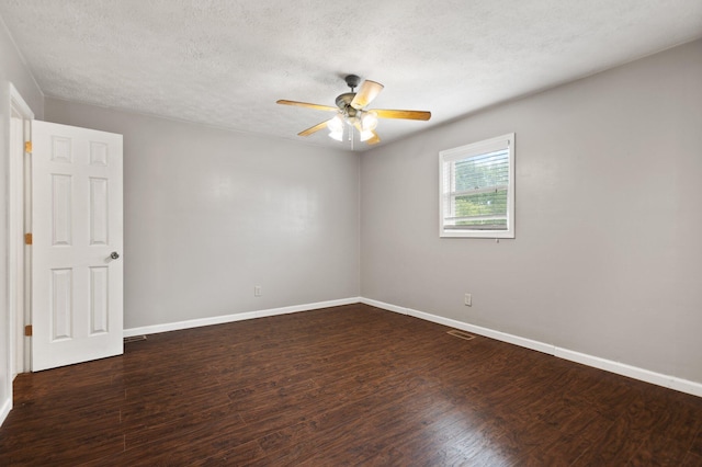 empty room with dark wood-style floors, baseboards, and a textured ceiling