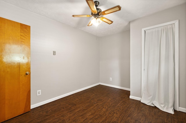 unfurnished bedroom featuring dark wood-style floors, a ceiling fan, and baseboards