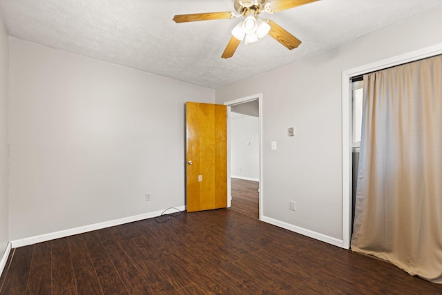 unfurnished bedroom with dark wood-type flooring, ceiling fan, a textured ceiling, and baseboards