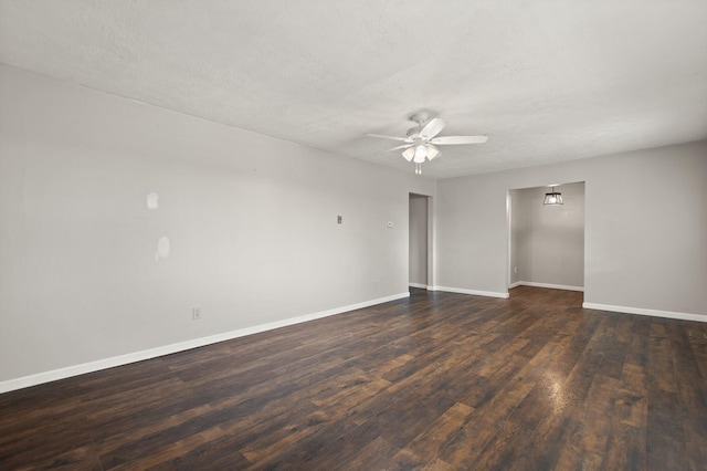 unfurnished room with dark wood-style floors, a textured ceiling, baseboards, and a ceiling fan