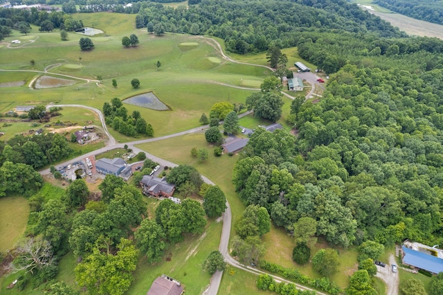 aerial view with view of golf course and a wooded view