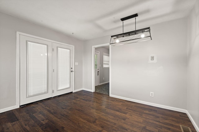 unfurnished dining area featuring baseboards, visible vents, and dark wood-type flooring