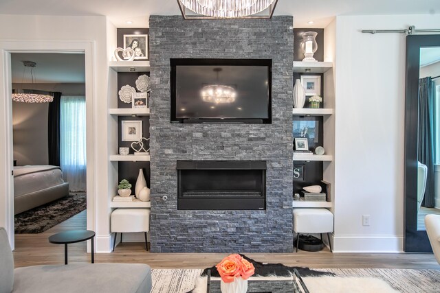 living room with built in features, a fireplace, and hardwood / wood-style flooring