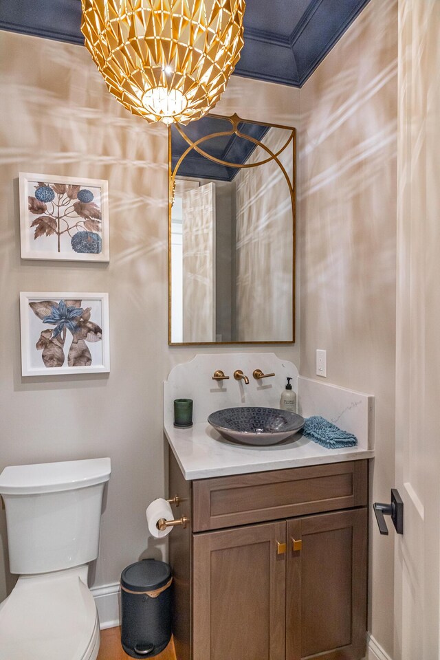 bathroom with vanity, crown molding, and toilet