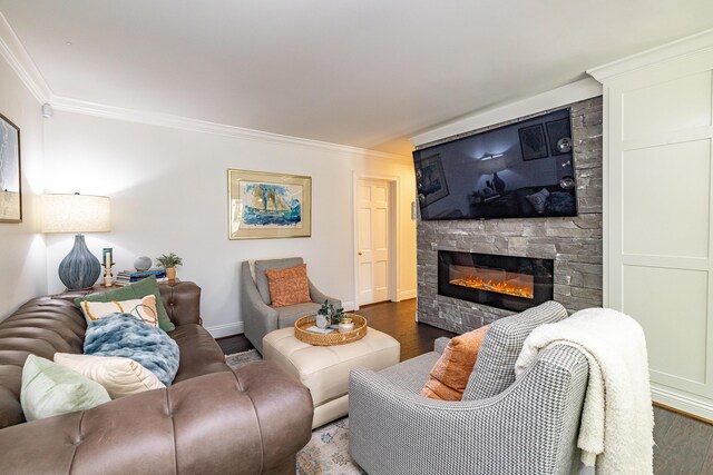 living room featuring a stone fireplace, dark wood-type flooring, and crown molding