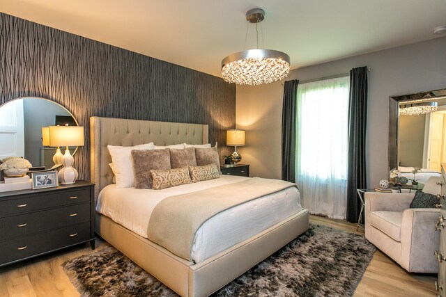 bedroom featuring light hardwood / wood-style flooring and a chandelier