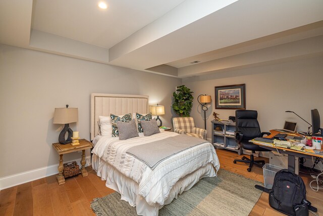 bedroom featuring a raised ceiling and hardwood / wood-style floors