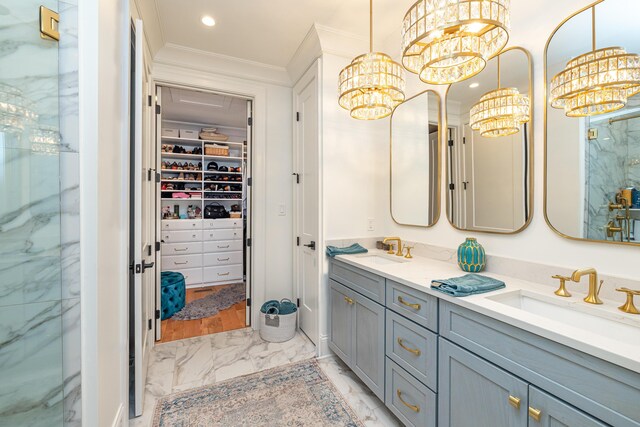 bathroom with a notable chandelier, double sink vanity, crown molding, and tile patterned flooring