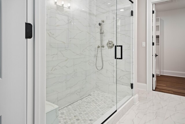 bathroom with wood-type flooring and an enclosed shower