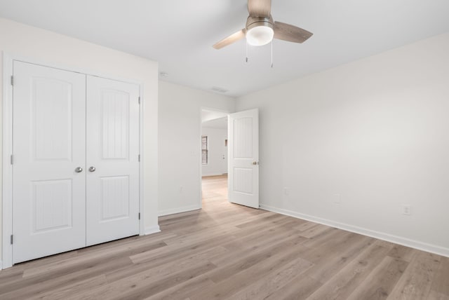 unfurnished bedroom with light hardwood / wood-style floors, a closet, and ceiling fan